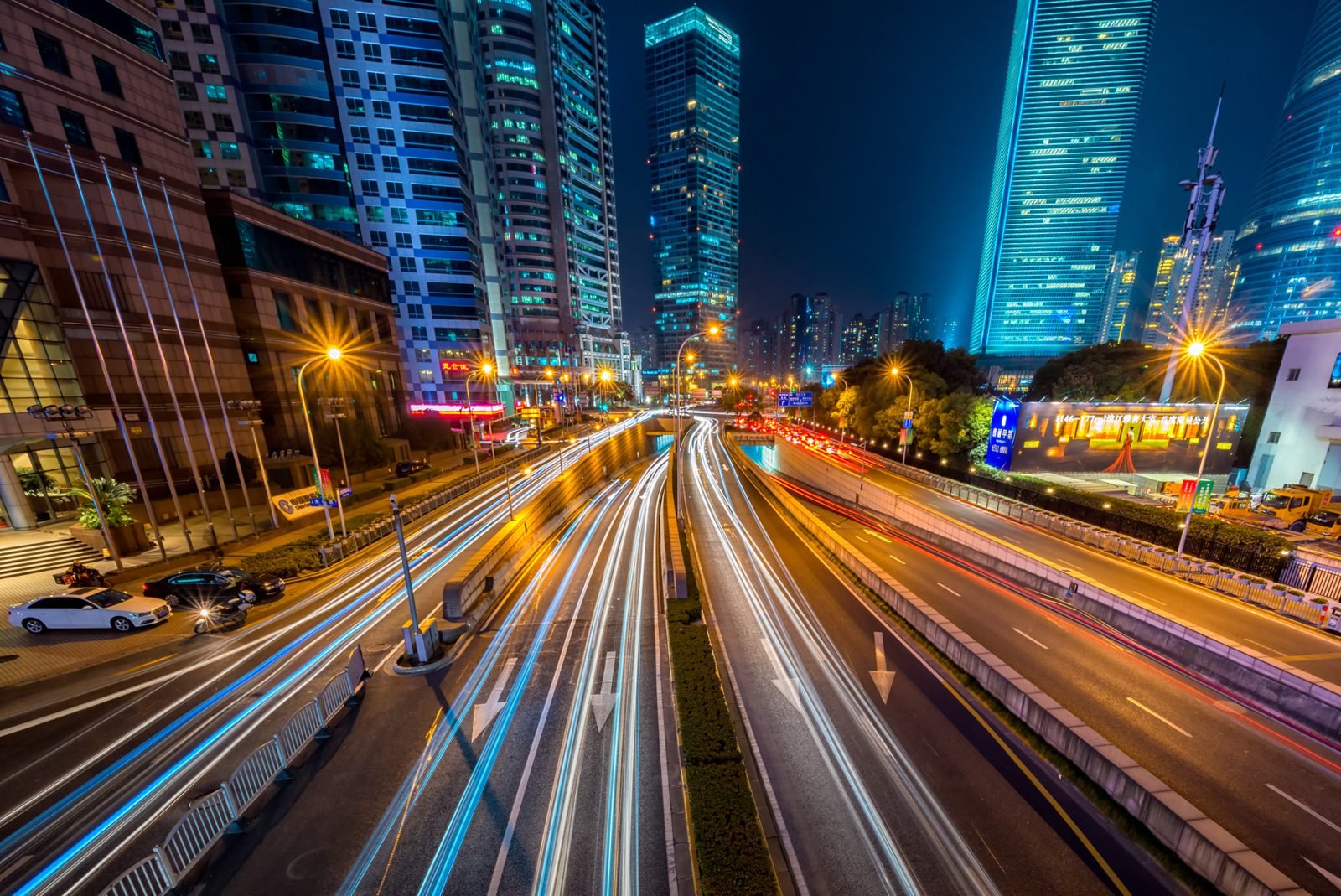 Avenida urbana de noche con estelas de luz del tránsito