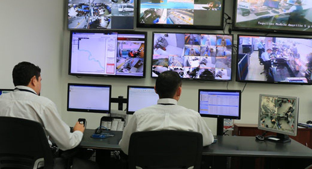 Centro de monitoreo con operadores frente a una pared de pantallas