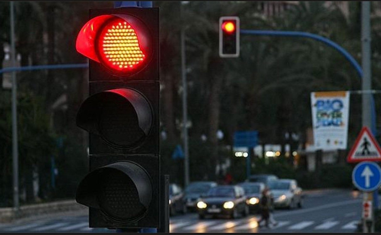 Semáforo en rojo frente a un cruce peatonal